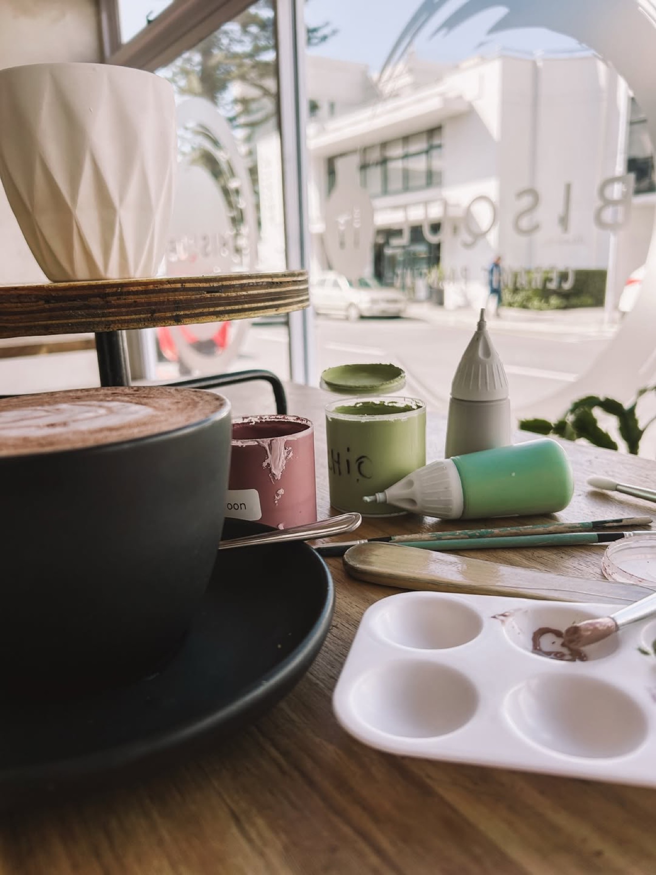 Pottery paints beside a cup of coffee